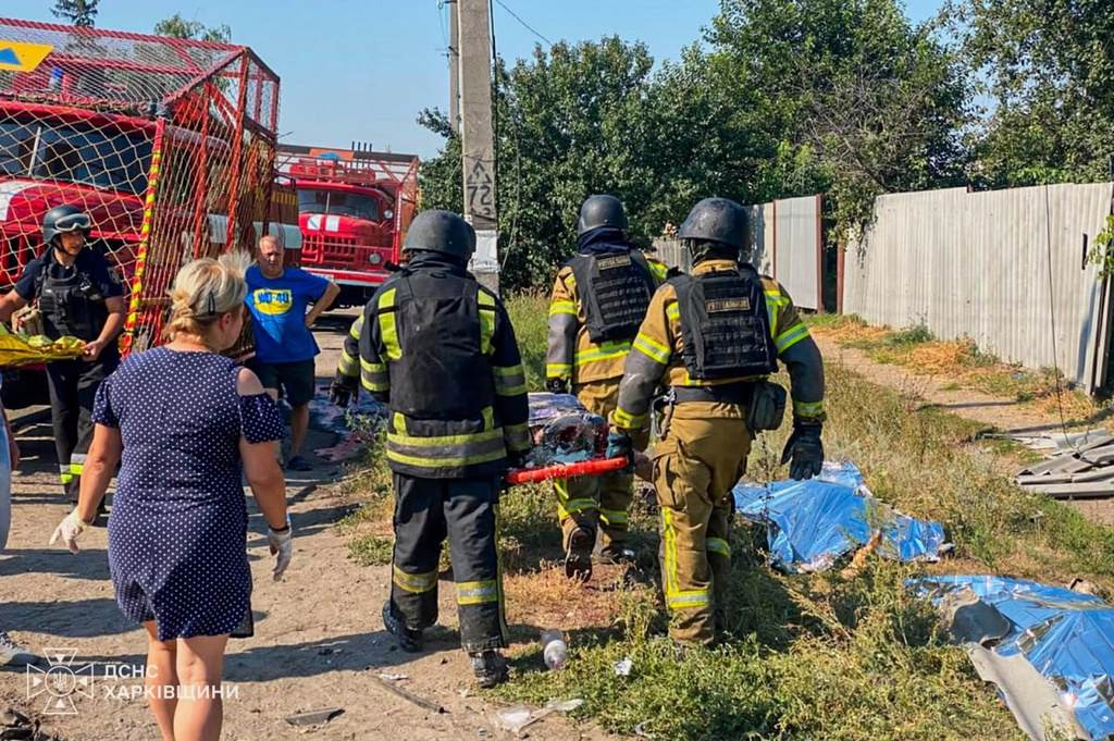 EDS NOTE: GRAPHIC CONTENT - In this photo, provided by the Ukrainian Emergency Service, rescuers carry a body that they removed from under the rubble of a private house following a Russian air attack in Pechenihy, Kharkiv region, Ukraine, Tuesday, Aug. 18, 2026. (Ukrainian Emergency Service via AP)