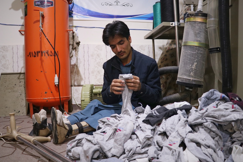 Masood Khan, sorts freshly made socks to be packaged in a sock workshop staffed entirely by men with disabilities in the western Afghan city of Herat, Afghanistan, Monday, Dec. 8, 2025. (AP Photo/Omid Haqjoo)