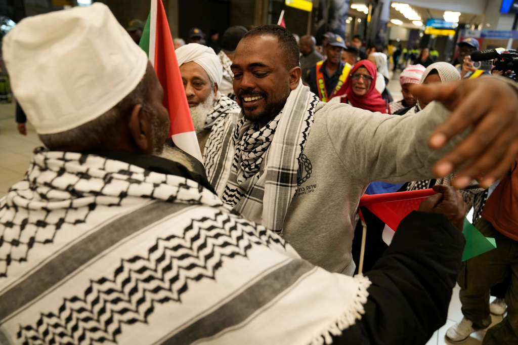 Ebrahim Peters, right, an activist embraces his family member after returning home at OR Tambo International Airport, in Johannesburg, South Africa, Saturday, May 23, 2026. (AP Photo/Themba Hadebe)