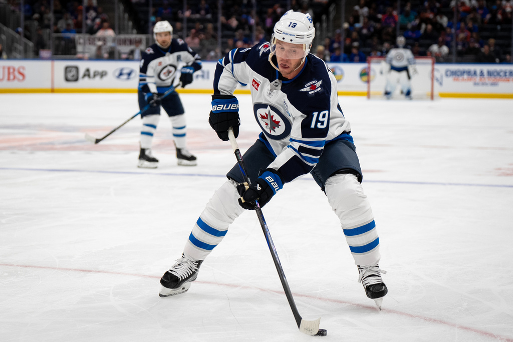 Winnipeg Jets center Jonathan Toews (19) controls the puck during the second period of an NHL hockey game against the New York Islanders, Monday, Oct. 13, 2025, in Elmont, N.Y. (AP Photo/Angelina Katsanis)