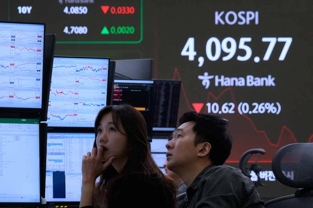 Currency traders watch monitors near a screen showing the Korea Composite Stock Price Index (KOSPI) at the foreign exchange dealing room of the Hana Bank headquarters in Seoul, South Korea, Wednesday, Nov. 12, 2025. (AP Photo/Ahn Young-joon)