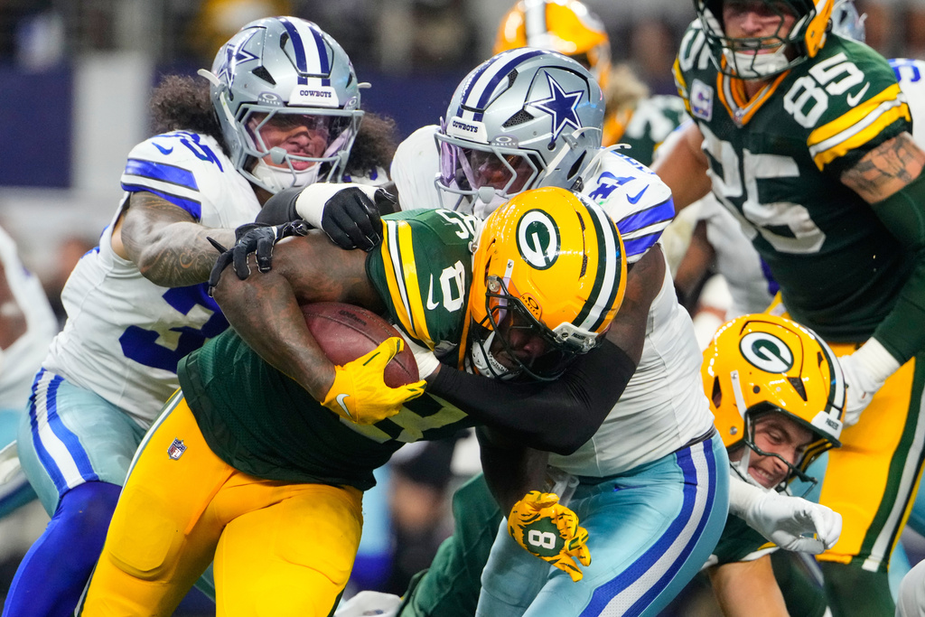 Green Bay Packers' Josh Jacobs (8) is stopped after a short gain by Dallas Cowboys defensive end Donovan Ezeiruaku (41) in the second half of an NFL football game Sunday, Sept. 28, 2025, in Arlington, Texas. (AP Photo/Jeffrey McWhorter)