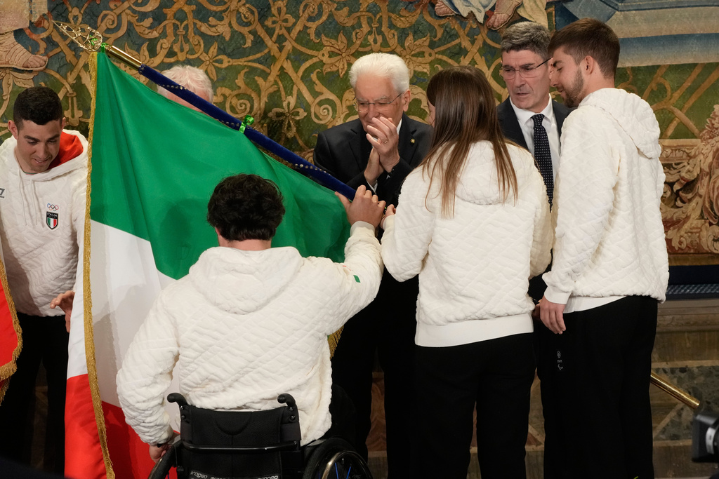 Italian athletes Rene' De Silvestro, left and Chiara Mazzel receive the Italian flag from Italian President Sergio Mattarella for the Milan-Cortina Winter Olympic games, at the Quirinale Presidential palace, in Rome, Monday, Dec. 22, 2025. (AP Photo/Gregorio Borgia)