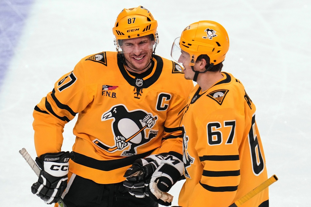 Pittsburgh Penguins' Sidney Crosby, left, celebrates his second goal of the first period with Rickard Rakell during an NHL hockey game against the Detroit Red Wings in Pittsburgh, Thursday, Jan. 1, 2026. (AP Photo/Gene J. Puskar)