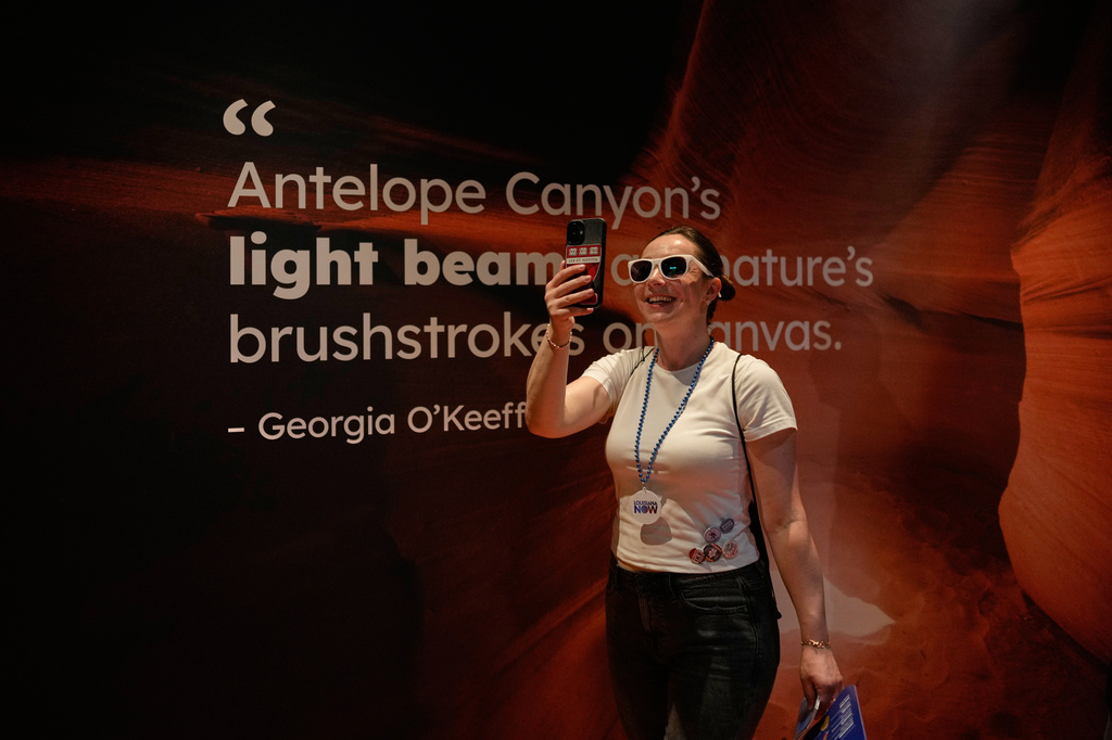 Natalia Romanova from Kazakstan uses a smartphone in Arizona's interactive exhibit during the Great American State Fair on Friday, June 26, 2026, in Washington. (AP Photo/Carolyn Kaster)