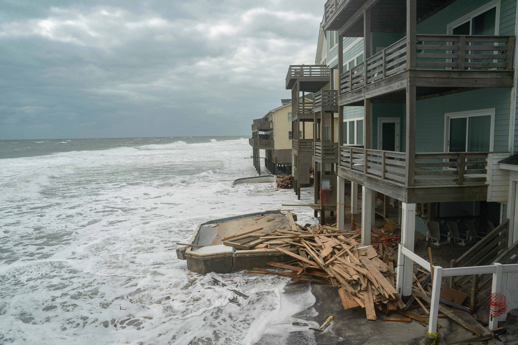 Debris washes up onto an old swimming pool as a storm approaches Friday, Oct. 10, 2025, in Buxton, N.C. (AP Photo/Allison Joyce)