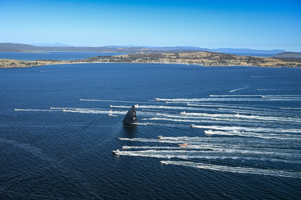 In this photo provided by the Cruising Yacht Club of Australia Comanche, center, is escorted by spectator craft as it crosses the finish line in Hobart, Australia, Sunday, Dec. 28, 2025, to claim line honors in the Sydney Hobart yacht race. (Kurt Arrigo/CYCA via AP)