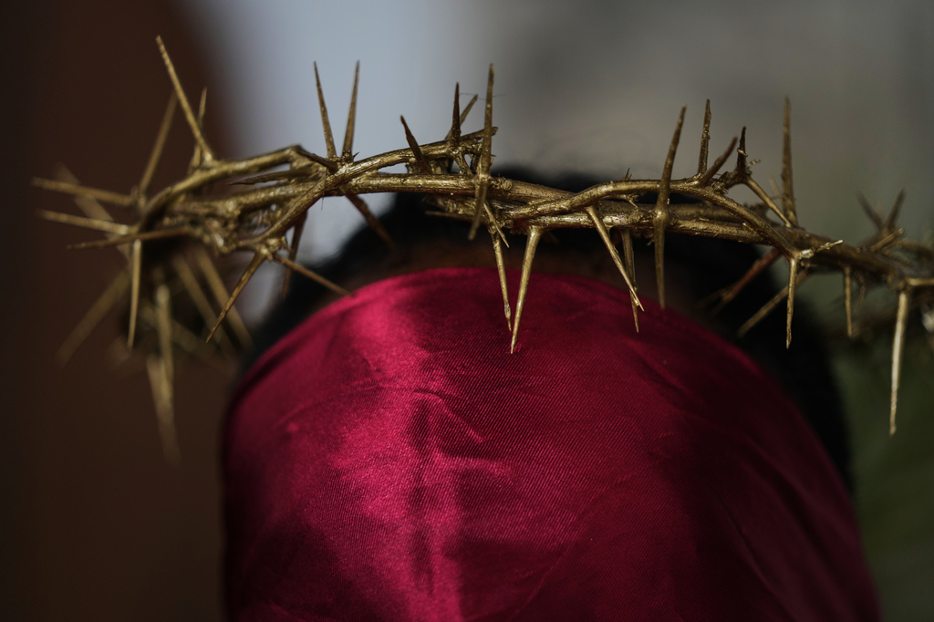 A hooded penitent, wearing prickly cactus thorns on his head, prepares to walk in a Good Friday procession during Holy Week in Atlixco, Mexico, Friday, April 3, 2026. (AP Photo/Fernando Llano)