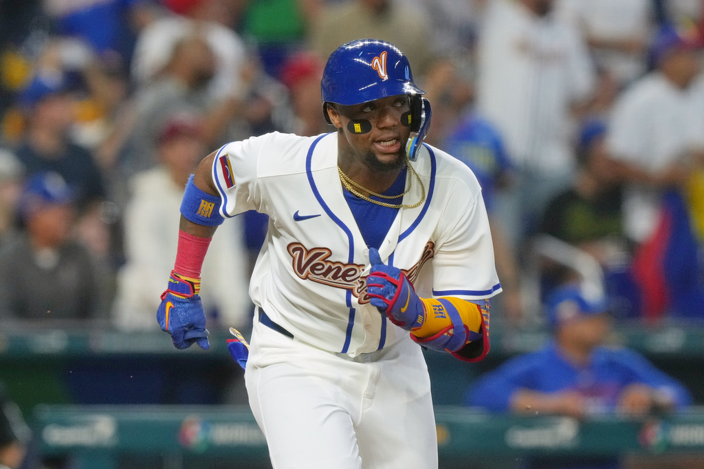 Venezuela's Ronald Acuña Jr. (21) runs to first base after hitting a double to center field during a World Baseball Classic game against the Netherlands, Friday, March 6, 2026, in Miami. (AP Photo/Marta Lavandier)