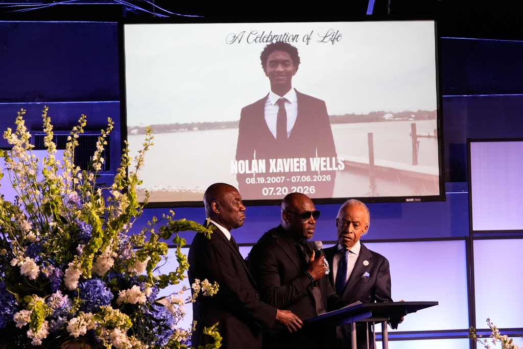 Elmore Wonsley, center, speaks next to attorney Ben Crump, left, and Rev. Al Sharpton during a memorial service for Nolan Xavier Wells, an 18-year-old found dead after taking a July 4 boat trip with friends, Monday, July 20, 2026, in Ocean Springs, Miss. (AP Photo/Gerald Herbert)