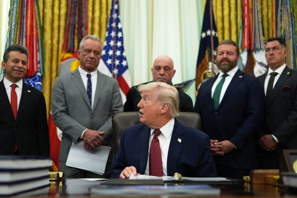 President Donald Trump turns to speak to Dr. Marty Makary, commissioner of the Food and Drug Administration, left, in the Oval Office of the White House, Saturday, April 18, 2026, in Washington. (AP Photo/Julia Demaree Nikhinson)