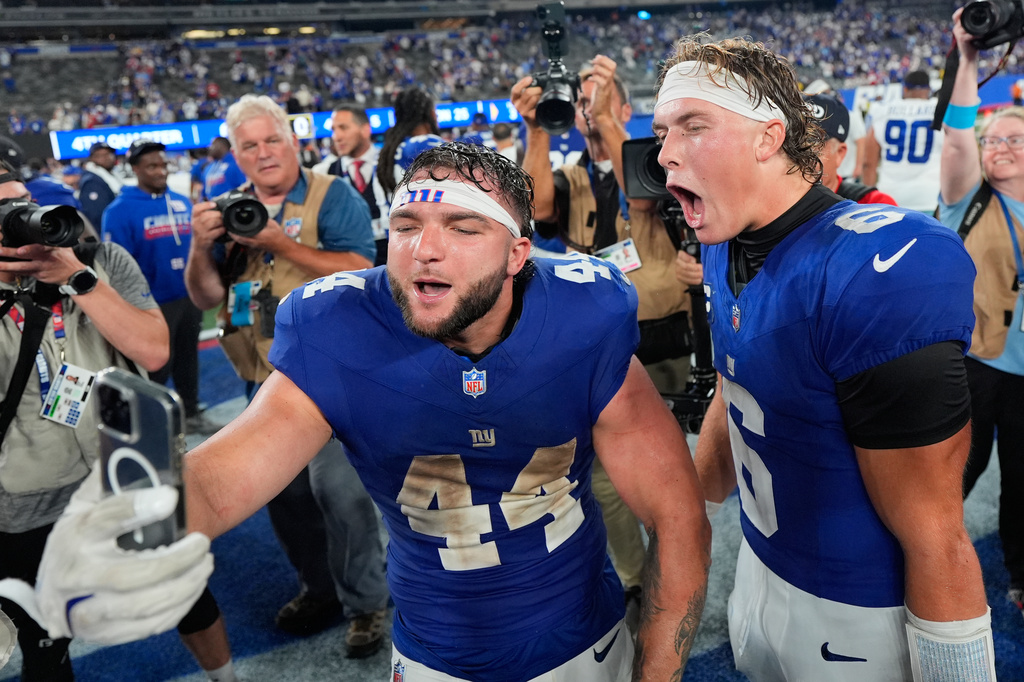New York Giants running back Cam Skattebo (44) and quarterback Jaxson Dart (6) react with a cell phone following an NFL football game against the Dallas Cowboys Sunday, Sept. 13, 2026, in East Rutherford, N.J. (AP Photo/Yuki Iwamura)