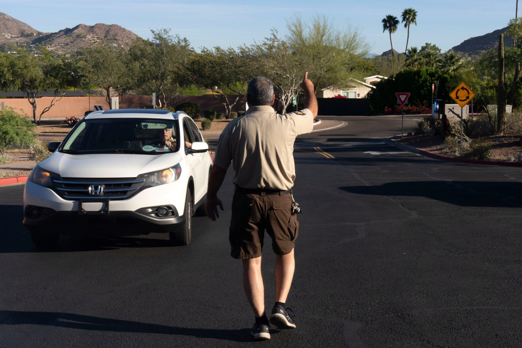City of Phoenix Park Ranger Sam Weller directs hikers away from a trailhead closed due to extreme heat at Camelback Mountain on Thursday, March 19, 2026, in Phoenix. (AP Photo/Rebecca Noble)