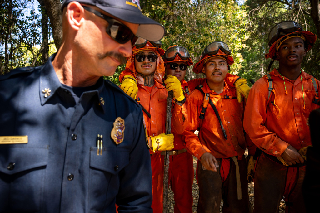 Pine Grove Youth Conservation Camp inmates pause while clearing brush along a road, July 14, 2025, near Red Corral, Calif. (AP Photo/Ethan Swope)