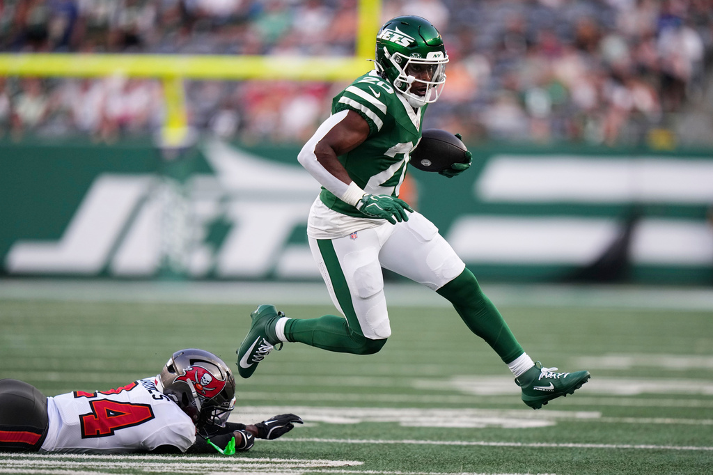New York Jets running back Breece Hall (20) runs from Tampa Bay Buccaneers cornerback Ayden Garnes, left, during the first half of a preseason NFL football game, Friday, Aug. 14, 2026, in East Rutherford, N.J. (AP Photo/Frank Franklin II)