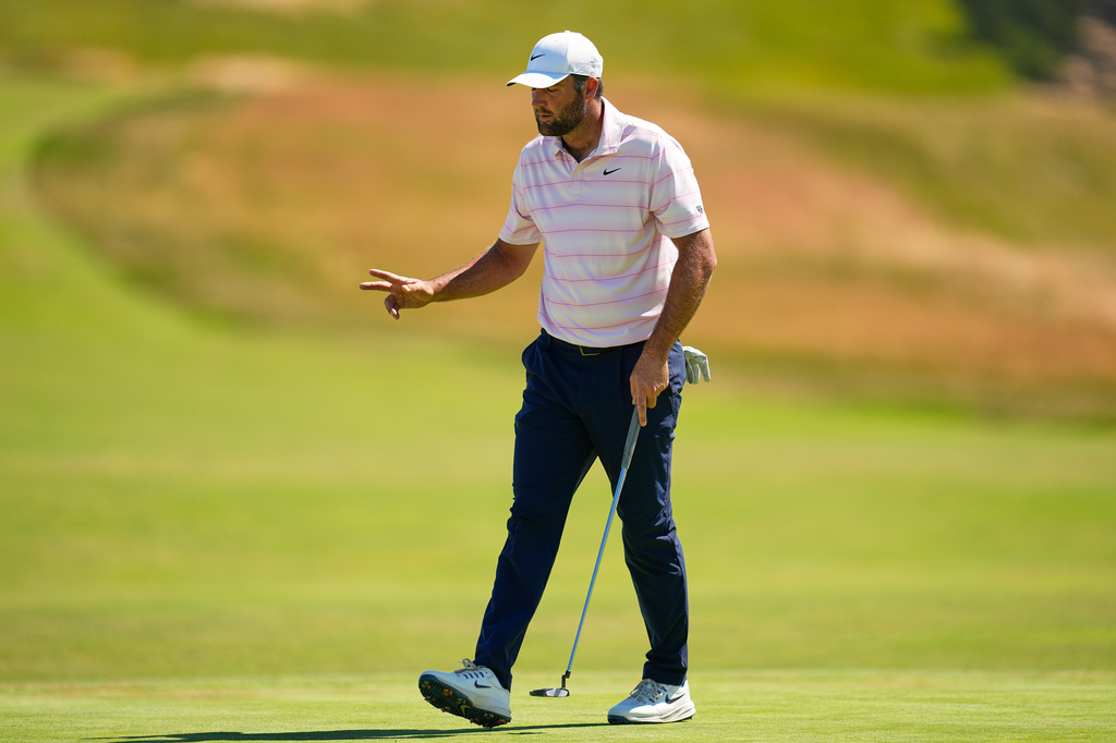 Scottie Scheffler waves after his putt on the third hole during the final round of the U.S. Open golf tournament at Shinnecock Hills Golf Club in Southampton, N.Y., Sunday, June 21, 2026. (AP Photo/George Walker IV)