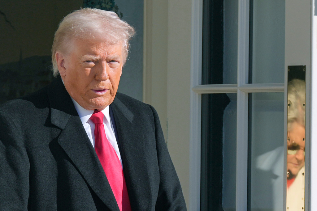 President Donald Trump and White House Chief of Staff Susie Wiles, reflected on door, leave to board Marine One, Tuesday, Jan. 13, 2026, in Washington. (AP Photo/Mark Schiefelbein)