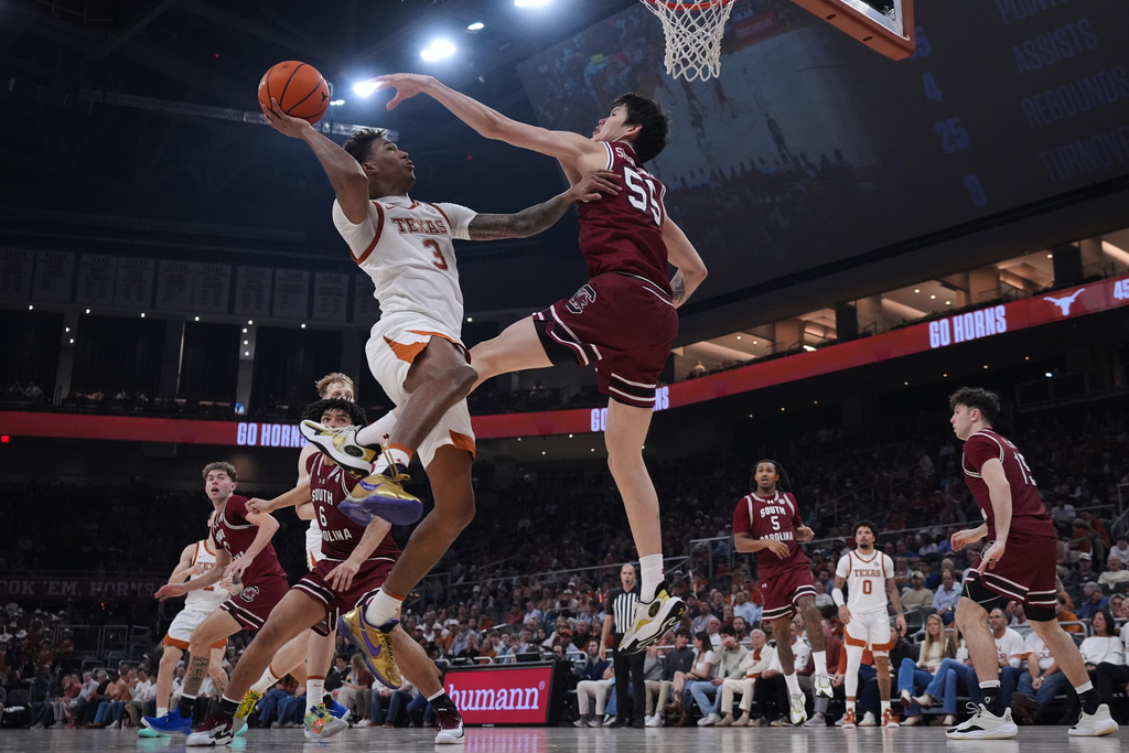 Texas forward Dailyn Swain (3) drives to the basket against South Carolina guard Mike Sharavjamts (55) during the second half of an NCAA college basketball game in Austin, Texas, Feb. 3, 2026. (AP Photo/Eric Gay)