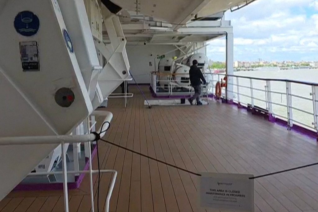 A man walks on a deck of the British cruise ship the Ambition after 1,700 passengers and crew were ordered to remain on board after an outbreak of gastrointestinal illness, in the port of Bordeaux, France, Wednesday, May 13, 2026. (Kevin Starrs via AP)
