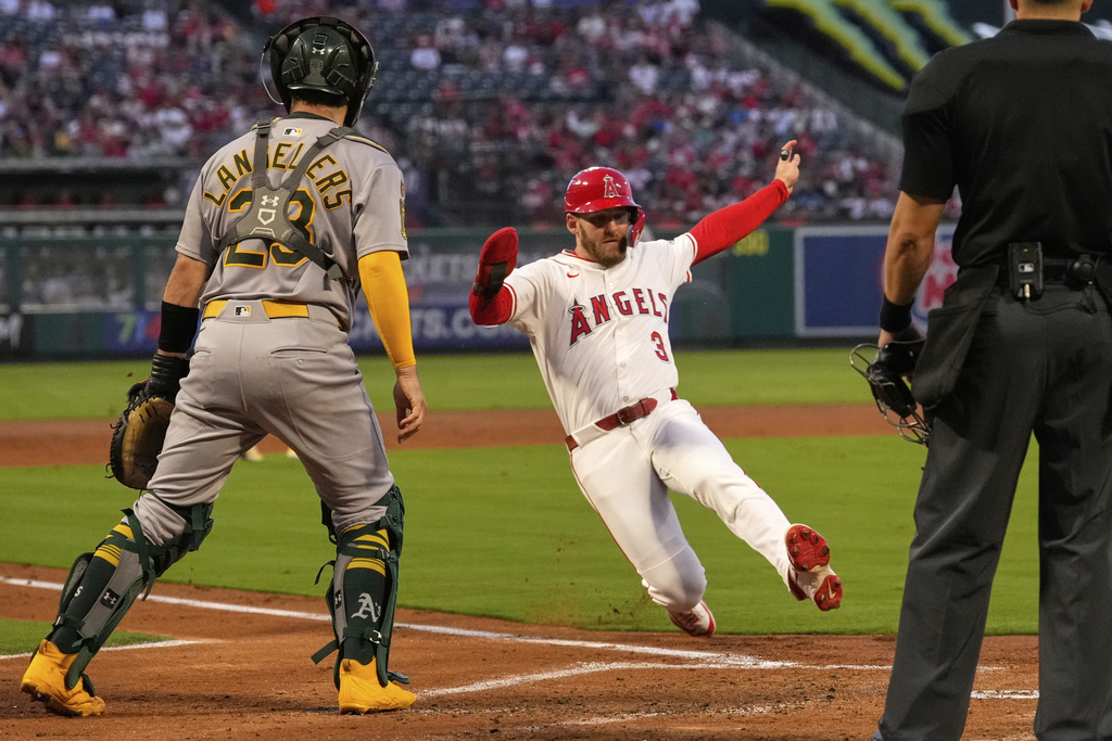 Los Angeles Angels' Taylor Ward,, center, scores on a single by Oswald Peraza as Athletics catcher Shea Langeliers stands by during the first inning of a baseball game Friday, Sept. 5, 2025, in Anaheim, Calif. (AP Photo/Mark J. Terrill)