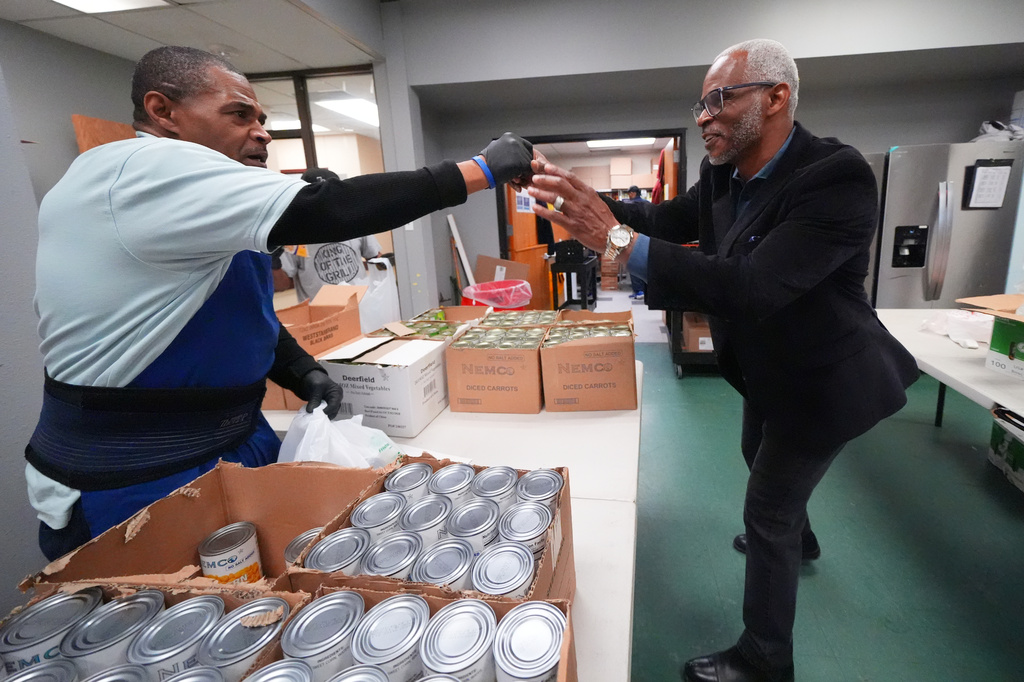 Richard Miles, right, founder and CEO of Miles of Freedom, a Dallas-based group that provides help for individuals after they have been released from prison, whether they are on parole or are exonerees, greets his organization's soup kitchen volunteer Frederick Briscoe on Tuesday, April 21, 2026 in Dallas. (AP Photo/Julio Cortez)