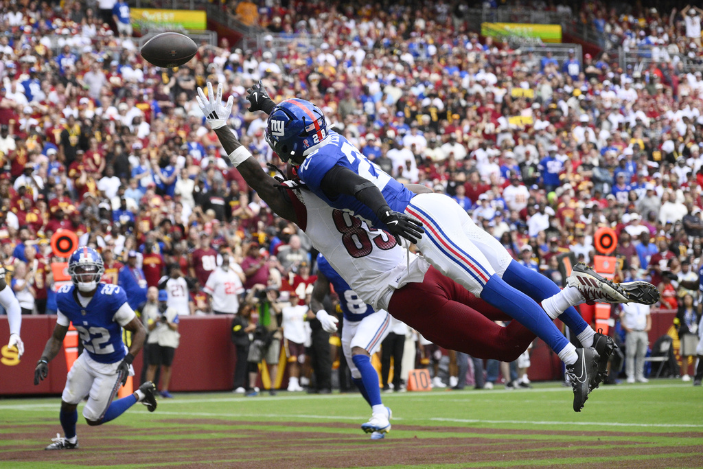 New York Giants cornerback Cor'Dale Flott (28) breaks up a pass intended for Washington Commanders wide receiver Noah Brown (85) during the first half of an NFL football game, Sunday, Sept. 7, 2025, in Landover, Md. (AP Photo/Nick Wass)