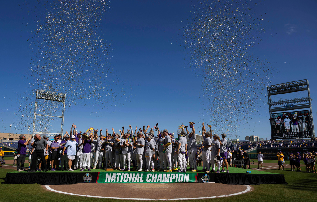FILE - LSU LSUhead coach Jay Johnson hoists the championship trophy with his team following their win over Coastal Carolina in the NCAA College World Series baseball finals in Omaha, Neb., June 22, 2025. (AP Photo/Rebecca S. Gratz, file)