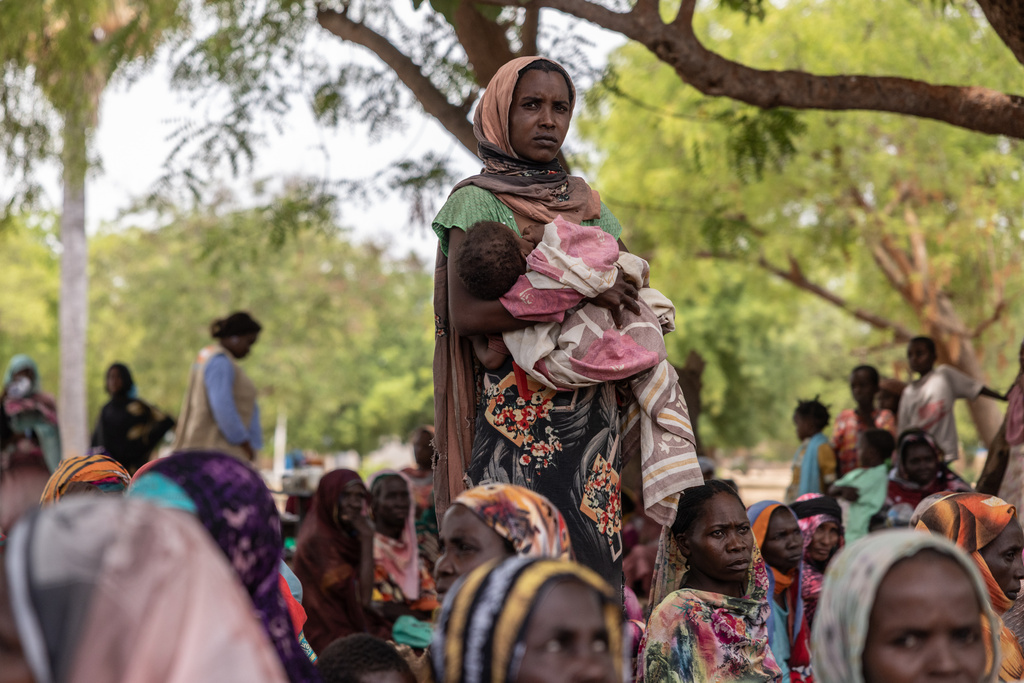 A woman holds her baby outside the registration center for new refugees on the outskirts of the Korsi Refugee Camp in Birao, Central African Republic, Thursday, March 26, 2026. (AP Photo/Caitlin Kelly)