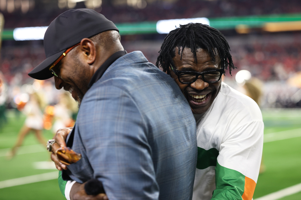 Former NFL players Ray Lewis, left, jokes with Michael Irvin during the first half of the Cotton Bowl College Football Playoff quarterfinal game between Ohio State and Miami Wednesday, Dec. 31, 2025, in Arlington, Texas. (AP Photo/Gareth Patterson)