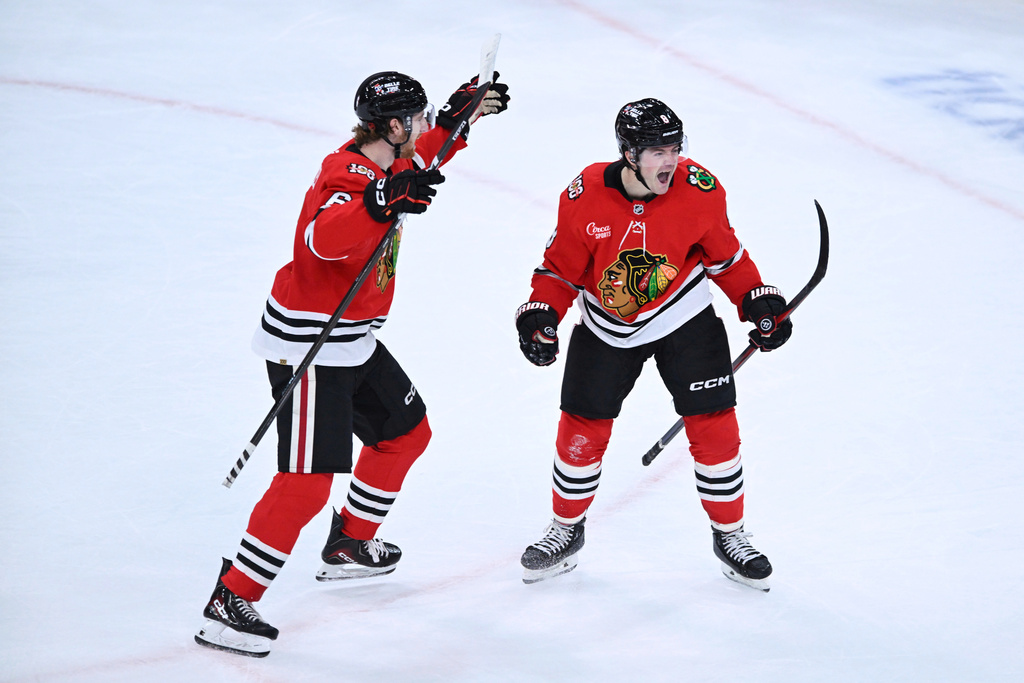 Chicago Blackhawks' Ryan Donato, right, celebrates with teammate Sam Rinzel, left, after scoring the winning goal in overtime of an NHL hockey game against the Anaheim Ducks, Sunday, Oct. 19, 2025, in Chicago. (AP Photo/Paul Beaty)