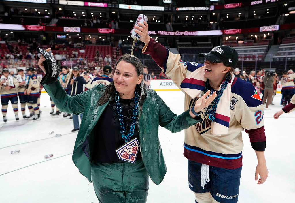 Montreal Victoire's Jessica DiGirolamo (right) pours a beer on head coach Kori Cheverie as they celebrate the team's PWHL Walter Cup win against the Ottawa Charge, in Ottawa, on Wednesday, May 20, 2026. (Justin Tang/The Canadian Press via AP) CORRECTION: name of photographer Justin Tang