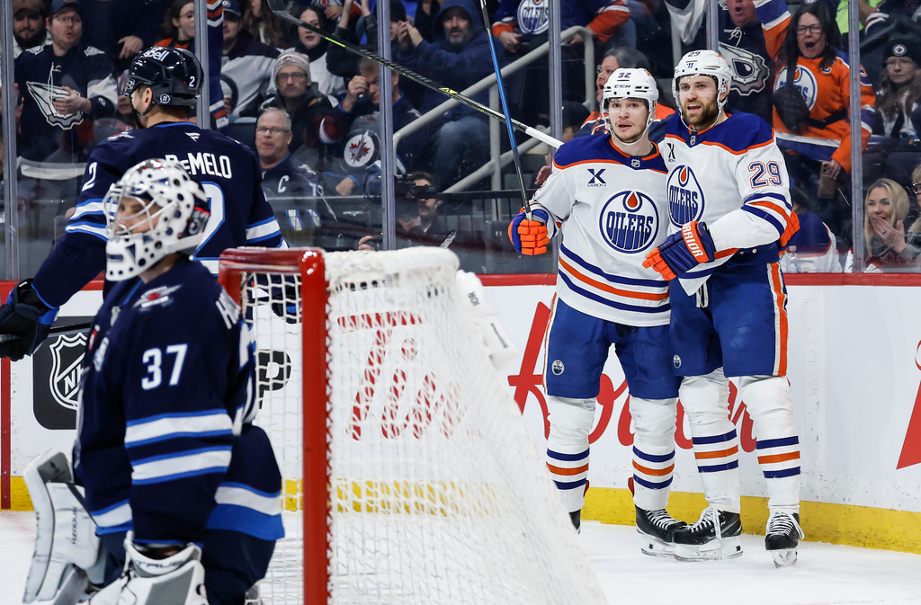 Edmonton Oilers' Vasily Podkolzin (92) and Leon Draisaitl (29) celebrate after Podkolzin's goal against the Winnipeg Jets during first-period NHL hockey game action in Winnipeg, Manitoba, Thursday, Jan. 8, 2026. (John Woods/The Canadian Press via AP)