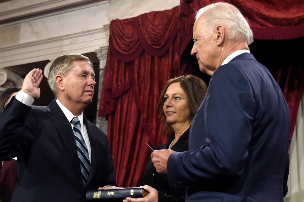 FILE - Vice President Joe Biden, right, administers the Senate oath to Sen. Lindsey Graham, R-S.C., left, as Graham's sister Darline Graham looks on during a ceremonial re-enactment swearing-in ceremony, Jan. 6, 2015, in the Old Senate Chamber on Capitol Hill in Washington. (AP Photo/Susan Walsh, File)