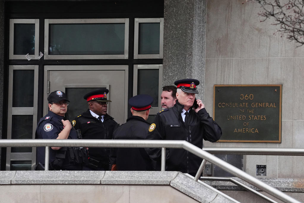 Toronto police officers investigate outside the U.S. consulate in Toronto on Tuesday March 10, 2026. (Frank Gunn/The Canadian Press via AP)