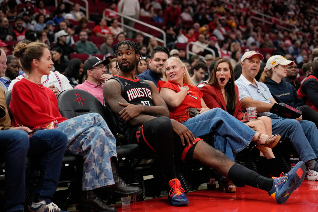 Houston Rockets forward Tari Eason (17) sits with fans during an extended officials timeout in the first half of an NBA basketball game against the Phoenix Suns Monday, Jan. 5, 2026, in Houston. (AP Photo/David J. Phillip)