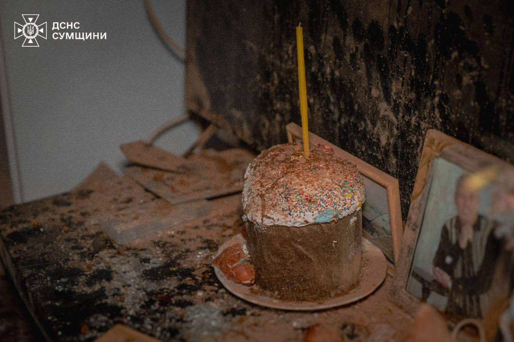 In this photo provided by the Ukrainian Emergency Services on Saturday, April 11, 2026, en easter bread with a candle covered by dust is seen inside an apartment of residential house damaged after a Russian drone strike on Sumy, Ukraine. (Ukrainian Emergency Service via AP)