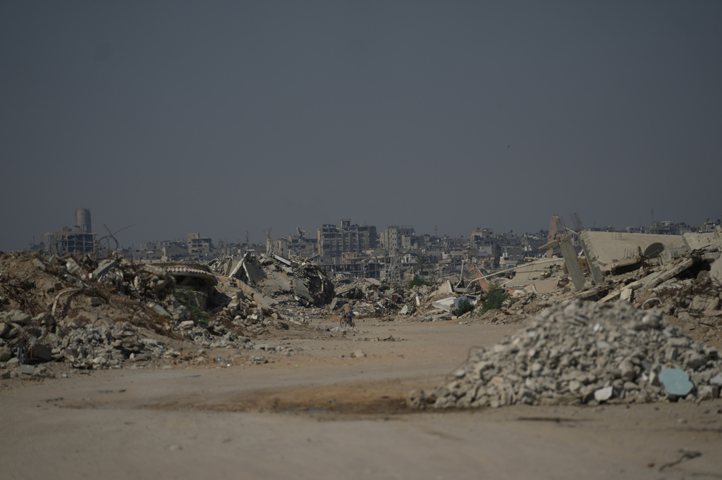 A Palestinian man rides his bicycle by the rubble of buildings that were destroyed during the Israel Hamas war, in Khan Younis, southern Gaza Strip, Friday, July 31, 2026. (AP Photo/Abdel Kareem Hana)