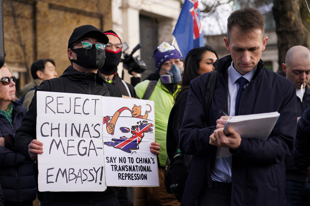 Demonstrators hold placards and flags as they attend a protest against the opening of the new Chinese embassy, in London, Saturday, Jan. 17, 2026. (AP Photo/Alberto Pezzali)