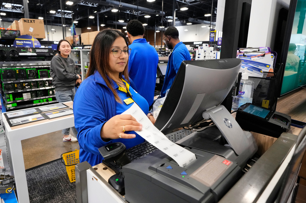 Abril Renteria, an Apple certified advisor, helps a customer check out after their purchase at a Best Buy store, Wednesday, Nov. 26, 2025, in Dallas. (AP Photo/Tony Gutierrez)