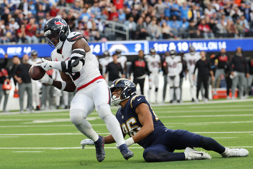 Houston Texans linebacker Azeez al-Shaair (0) intercepts a pass against Los Angeles Chargers tight end Oronde Gadsden (86) during the first half of an NFL football game Saturday, Dec. 27, 2025, in Inglewood, Calif. (AP Photo/Kevork Djansezian)