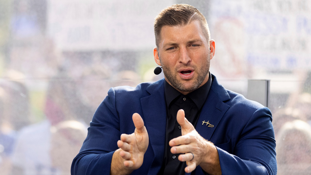 FILE - Tim Tebow talks to his co-hosts during the SEC Nation broadcast in Lexington, Ky., Oct. 9, 2021. (AP Photo/Michael Clubb, file)