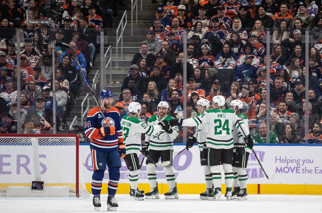 Dallas Stars celebrate a goal as Edmonton Oilers' Mattias Ekholm (14) skates past during the second period of an NHL hockey game in Edmonton, Alberta, Tuesday, Nov. 25, 2025. (Jason Franson/The Canadian Press via AP)