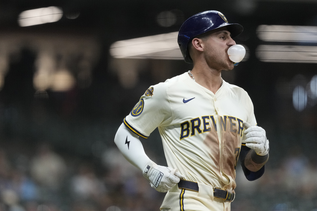 Milwaukee Brewers' Joey Ortiz blows a gum bubble as he jogs toward first base after flying out during the eighth inning of a baseball game against the Pittsburgh Pirates, Monday, Aug. 11, 2025, in Milwaukee. (AP Photo/Aaron Gash)