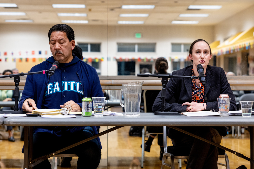 Seattle mayor Bruce Harrell, left, listens as mayoral candidate Katie Wilson, right, speaks during a climate forum Thursday, Oct. 16, 2025, in Seattle. (AP Photo/Maddy Grassy)