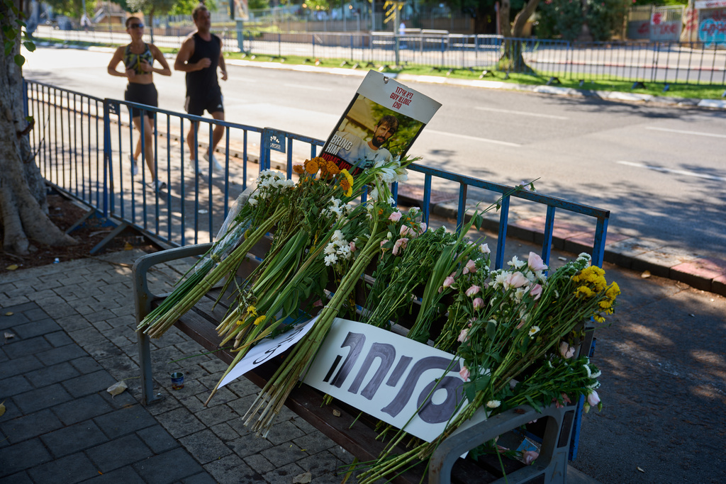 Flowers and a sign written in Hebrew reads "Sorry" are placed on a bench outside Abu Kabir, the forensic institute where the identification process is being carried out on the four bodies that were held by Hamas in the Gaza Strip, in Tel Aviv, Israel, Tuesday, Oct. 14, 2025. (AP Photo/Emilio Morenatti)