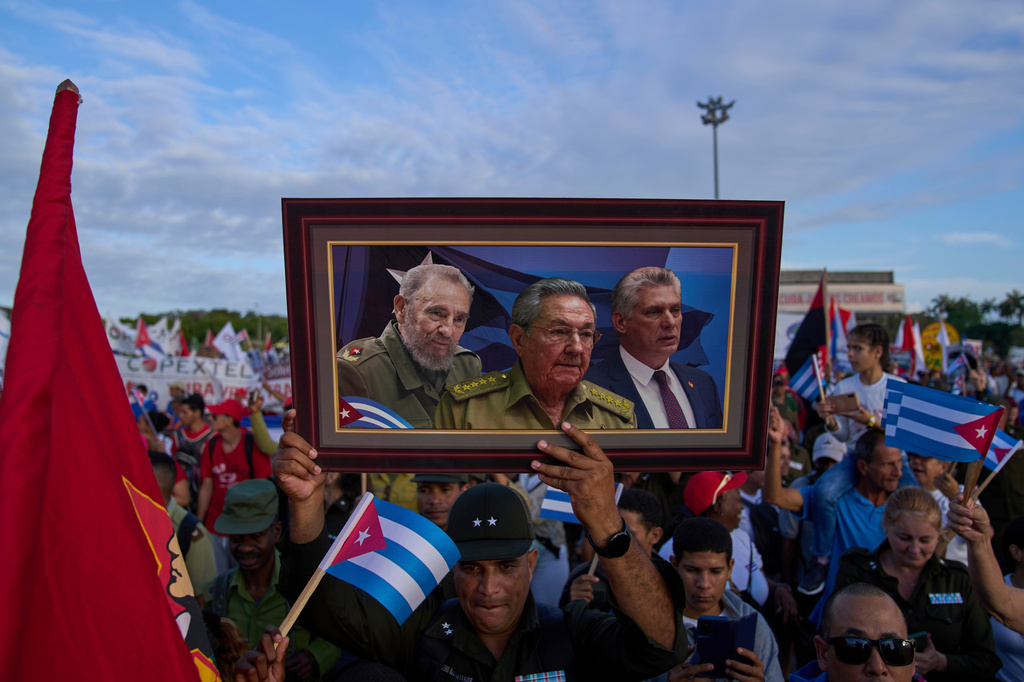 FILE - A marcher holds a framed composite image of Fidel Castro, Raul Castro and Cuba's President Miguel Diaz-Canel, during the May Day parade at Revolution Square in Havana, May 1, 2025. (AP Photo/Ramon Espinosa, File)