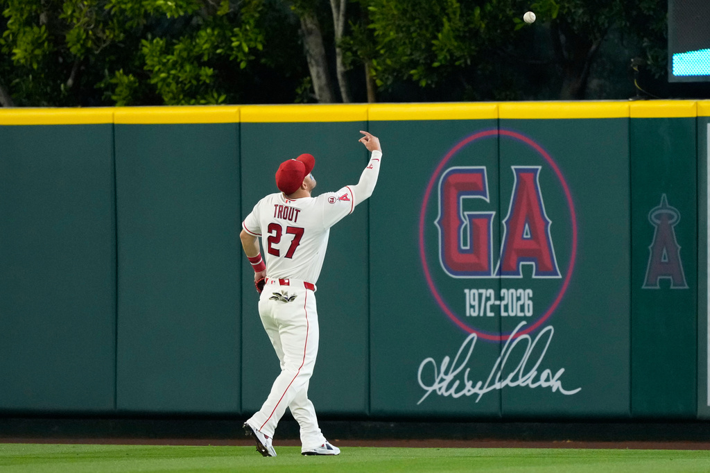 Los Angeles Angels right fielder Mike Trout tosses a ball to a fan in front of a tribute to former Angels player Garret Anderson during the fifth inning of a baseball game against the San Diego Padres, Friday, April 17, 2026, in Anaheim, Calif. (AP Photo/Mark J. Terrill)