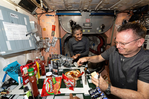 FILE - In this photo provided by NASA, astronauts Suni Williams and Butch Wilmore, both Expedition 71 flight engineers, make pizza aboard the International Space Station's galley located inside the Unity module on Sept. 9, 2024. Items are attached to the galley using tape and velcro to keep them from flying away in the microgravity environment. (NASA via AP, File) FILE - In this photo provided by NASA, astronauts Suni Williams and Butch Wilmore, both Expedition 71 flight engineers, make pizza aboard the International Space Station's galley located inside the Unity module on Sept. 9, 2024. Items are attached to the galley using tape and velcro to keep them from flying away in the microgravity environment. (NASA via AP, File)