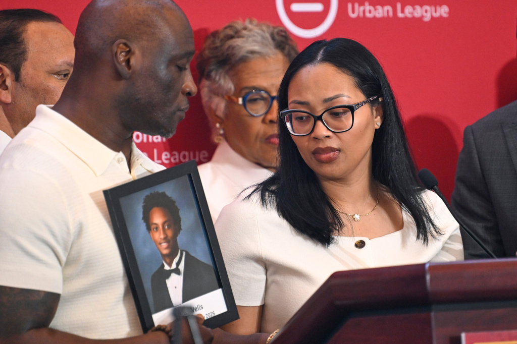 Christine Wonsley looks at a photo of her deceased son Nolan Wells, as husband Elmore Wonsley, left, stands at her side as they appear at the National Urban League's annual conference, Thursday, July 30, 2026, in Nashville, Tenn. (AP Photo/John Amis)