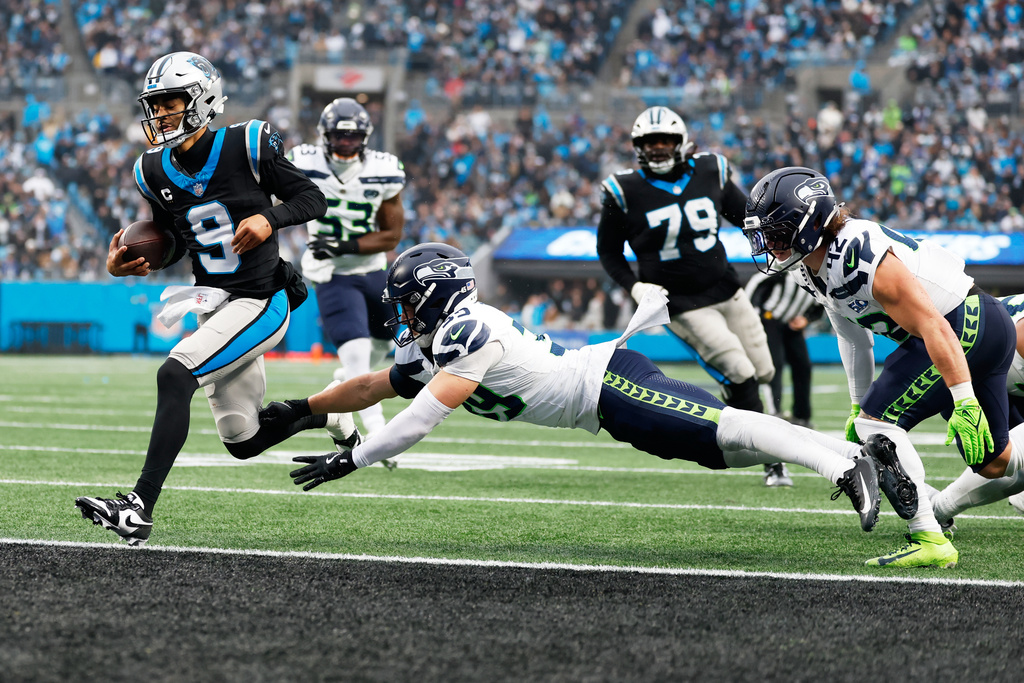 Carolina Panthers quarterback Bryce Young scores past Seattle Seahawks safety Ty Okada during the second half of an NFL football game, Sunday, Dec. 28, 2025, in Charlotte, N.C. (AP Photo/Rusty Jones)